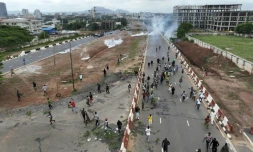 Vue aérienne de manifestants contre la vie chère à Abuja au Nigeria, le 2 août 2024, fuyant des tirs de gaz lacrymogène