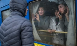 Une famille à bord d'un train d'évacuation fait ses adieux à un jeune homme resté sur place, le 6 mars 2022 en gare d'Odessa, dans le sud de l'Ukraine