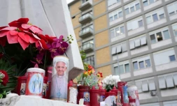 Des bougies déposées au pied d'une statue du pape Jean-Paul II à l'extérieur de l'hôpital Gemelli où le pape François est hospitalisé à Rome, le 20 février 2025