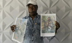 Un proche montre des photos de Kényans enrôlés de force dans l'armée russe en Ukraine lors d'une conférence de presse à Nairobi, le 27 janvier 2026, pour exiger du gouvernement leur rapatriement