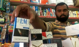 Un homme range des paquets de cigarettes à Ras al-Khaimah le 28 septembre 2017
