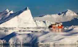 Un bateau de touristes navigue au milieu des icebergs dans la baie de Disko, le 1er juillet 2022 à Ilulissat, au Groenland 