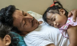 Jose Eliberto Hernandez Lopez, allongé avec sa fille Enya, dans un refuge pour migrants, à Matamoros, au Mexique, le 26 mai 2021