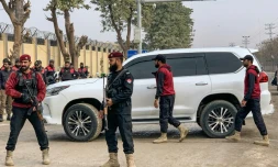 Des policiers autour d'un véhicule transportant Bushra Bibi, l'épouse de l'ancien premier ministre pakistanais Imran Khan, devant la prison d'Adiala, avant une audience dans une affaire de corruption, le 17 janvier 2025 à Rawalpindi