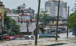 Des habitants réfugiés sur un toit alors que leur quartier est submergé par les eaux après le débordement de la rivière Bagmati  à Katmandou, le 28 septembre 2024