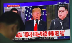 Les photos du président américain Donald Trump (g) et du leader nord-coréen Kim Jong Un sur un écran de télévision dans une gare de Séoul, le 25 mai 2018, après l'annulation du sommet entre les deux dirigeants