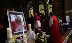 Des religieux passent devant un portrait de Desmond Tutu à la cathédrale Saint-Georges, au Cap le 30 décembre 2021