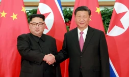 Photo fournie le 9 mai 2018 par l'agence nord-coréenne Kcna du leader nord-coréen Kim Jong Un et du président chinois Xi Jinping (d), lors d'une rencontre à Dalian, en Chine