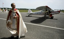 Le curé de Moissac en aube blanche, Pierre Hoan, à l'aérodrome Gandalou, le 21 mai 2022 à Castelsarrasin, dans le Tarn-et-Garonne