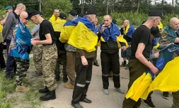Photo non datée publiée sur la chaîne Telegram officielle du président ukrainien Volodymyr Zelensky, le 19 juin 2025, de prisonniers de guerre ukrainiens (PG) enveloppés dans le drapeau national après un échange de prisonniers dans un lieu non divulgué en Ukraine
