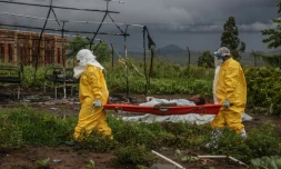 Du personnel médical transporte un patient sur un brancard à l'hôpital de Rwampara, le 21 mai 2026, en OUganda, tout près de la République Démocratique du Congo, touchée par une épidémie d'Ebola