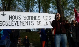 Une manifestante prend la parole devant une banderole du collectif écologiste "Les Soulèvements de la terre" à Paris, le 19 avril 2023