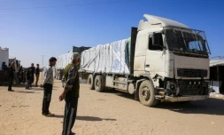 Des Palestiniens observent l'arrivée de camions transportant de l'aide humanitaire à Khan YounÚs, dans le sud de la bande de Gaza, aprÚs leur entrée par le cÎté égyptien du passage frontalier de Rafah, le 1er février 2026