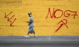 Un graffiti "No G7" sur un magasin protégé par des plaques de bois aggloméré, le 12 juin 2026 à Genève, en Suisse, avant les manifestations en marge du sommet du G7 à Evian, 