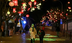 Des piétons dans une rue décorée de lanternes  à la veille de la nouvelle année lunaire du serpent à Pékin, le 28 janvier 2025