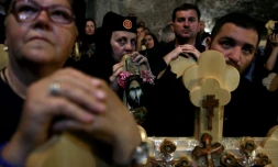 Des chrétiens orthodoxes serbes portent des croix de bois dans l'église Saint-Sépulcre à Jérusalem, le 29 avril 2016