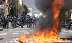 Gendarmes derriÚre un feu de déchets lors d'une manifestation de lycéens devant la préfecture de Corse du Sud le 10 mars 2022