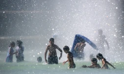 Des enfants se baignent dans le bassin de la Fontaine du Trocadéro, le 2 août 2018 à Paris pendant un épisode de canicule