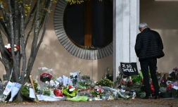 Un homme se recueille devant le collège du Bois d'Aulne à Conflans-Sainte-Honorine, où enseignait Samuel Paty, le 19 octobre 2020 