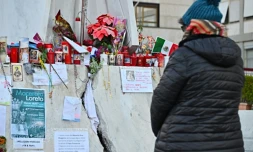 Une personne prie devant la statue de Jean-Paul II à l'extérieur de l'hôpital Gemelli à Rome où est soigné le pape François pour une pneumonie, le 6 mars 2025