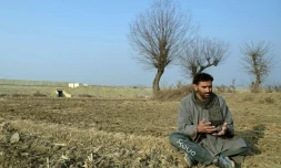 L'agriculteur Musadiq Hussain, lors d'une interview avec l'AFP, dans sa rizière près d'une autoroute en construction dans le district de Budgam, le 15 janvier 2025 au Cachemire indien