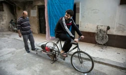 Un Syrien pédale sur un vélo relié à une vieille batterie pour produire de l'électricité, le 31 octobre 2016 à Alep