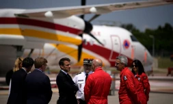 Le président Emmanuel Macron (c) écoute les agents de la sécurité civile lors de sa visite à la base aérienne des pompiers de Nîmes-Garons, le 2 juin 2023 à Garons, dans le Gard