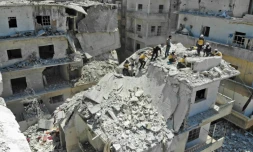 Des secouristes des Casques blancs cherchent des victimes à l'intérieur d'un immeuble visé par un raid du régime à Ariha, dans le nord-ouest en Syrie, le 27 juillet 2019