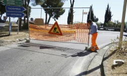Un ouvrier installe une barrière de signalisation de chantier sur la chaussée, le 4 mai 2017 à Taormina