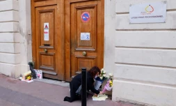 Une femme dépose des fleurs devant le lycée de la jeune Alisha à sa mémoire, le 10 mars 2021