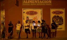 Des jeunes hommes consultent leurs téléphones portables à Torre Pacheco (Espagne), le 15 juillet 2025, alors qu'un rassemblement a été appelé par des groupes d'extrême droite après quatre jours de manifestations et de violences anti-migrants