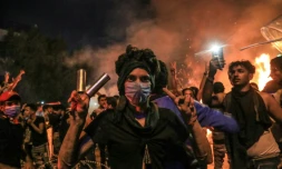 Un Irakien portant un masque Ă gaz et faisant le V de la victoire au cours d'une manifestation anti-gouvernementale Ă Kerbala, une ville chiite au sud de Bagdad le 28 octobre 2019