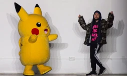 Le designer britannique Bobby Abley vient saluer avec un Pikachu géant à la fin de son défilé automne/hiver 2019 lors de la Fashion week hommes à Londres, le 5 janvier 2019
