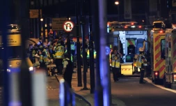 Des officiers de police et les services de secours sur le London Bridge, à Londres, le 3 juin 2017, où une camionnette a foncé sur la foule, un acte qualifié par la police de "terroriste"