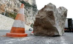 Une voiture passe derriÚre un rocher tombé suite à un éboulement à Beaulieu-Sur-Mer le 10 février 2013