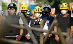 Des manifestants derrière une barricade font face aux forces de police, le 4 mars 2021 à Naypyidaw