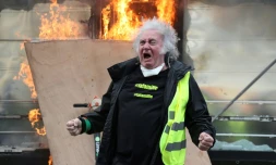Un "gilet jaune" devant un kiosque à journaux en feu sur les Champs Elysées, à Paris, le 16 mars 2019