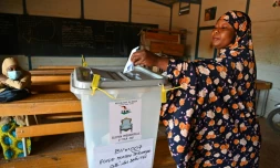 Une femme dépose son bulletin dans l'urne dans une salle classe transformée en bureau de vote à Niamey, le 21 février 2021 pour le second tour de la présidentielle