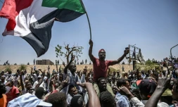 Des manifestants brandissent le drapeau soudanais lors d'un sit-in devant le QG de l'armée à Khartoum, le 22 avril 2019