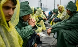 Un groupe de migrants sur des rails pendant une manifestation pour la réouverture de la frontière gréco-macédonienne, le 23 mars 2016