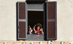 Des Italiens applaudissent depuis leur fenĂȘtre l'assouplissement du confinement, Ă Rome le 3 mai 2020