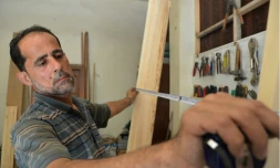 Le menuisier syrien Houssam Obeid dans son atelier de Saqba, dans la Ghouta orientale, près de Damas, le 13 août 2018