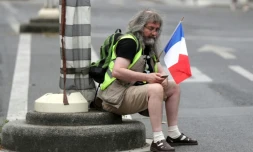 Un homme tient un drapeau français lors d'une manifestation anti-pass sanitaire le 21 août 2021 à Paris