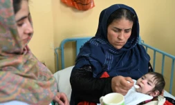 Samira (g), infirmière du service de malnutrition de l'hôpital de Baharak, donne du lait à la cuillère à une enfant, le 26 février 2024 dans la province du Badakhshan, en Afghanistan