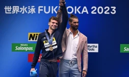 Le Français Leon Marchand félicité par l'Américain Michael Phelps, après lui avoir ravi le record du monde du 400 m 4 nages, aux Mondiaux de natation de Fukuoka, le 23 juillet 2023 