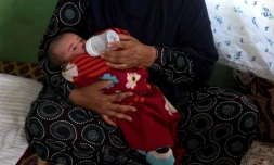 Le nouveau-nĂ© Mohmmad Ali, dans les bras d'un membre de sa famille, aprĂšs la mort de sa mĂšre, tuĂ©e dans l'attaque de la maternitĂ© oĂč elle venait d'accoucher, ici dans un lieu prĂšs de Kaboul le 22 mai 2020