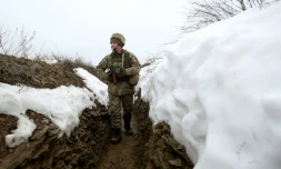 Un militaire ukrainien marche dans une tranchée sur la ligne de front avec les séparatistes prorusses près du village de Luganske, dans la région de Donetsk, le 11 janvier 2022
