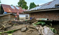 Une femme observe sa maison inondĂ©e Ă la suite de crues soudaines Ă Meureudu, dans la province dâAceh, en IndonĂ©sie, le 28 novembre 2025