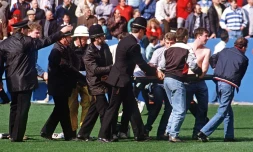 Des policiers transportent un supporteur blessé dans le stade de Hillsborough, le 15 avril 1989 à Sheffield, au Royaume-Uni