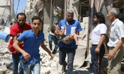 Un enfant blessé évacué aprÚs un raid aérien le 23 juillet 2016 à Alep en Syrie